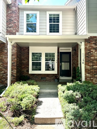 A house with a front porch and a black door.