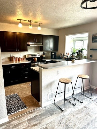 A kitchen with black cabinets and a white countertop.