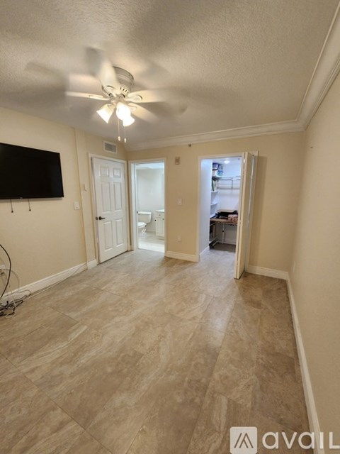A living room with a television and a ceiling fan.
