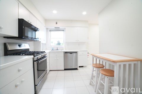 A kitchen with white cabinets and appliances.