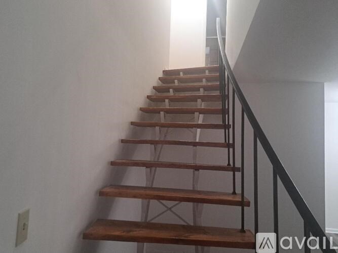 A wooden staircase with a metal railing.