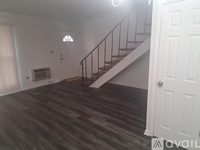 A room with a staircase and a door.