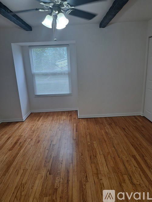 A room with wooden flooring and a ceiling fan.
