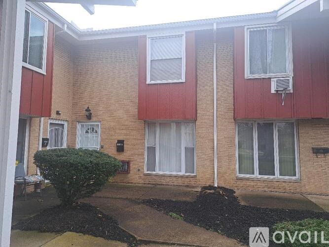 A red and beige building with a sign that says "available" in front of it.