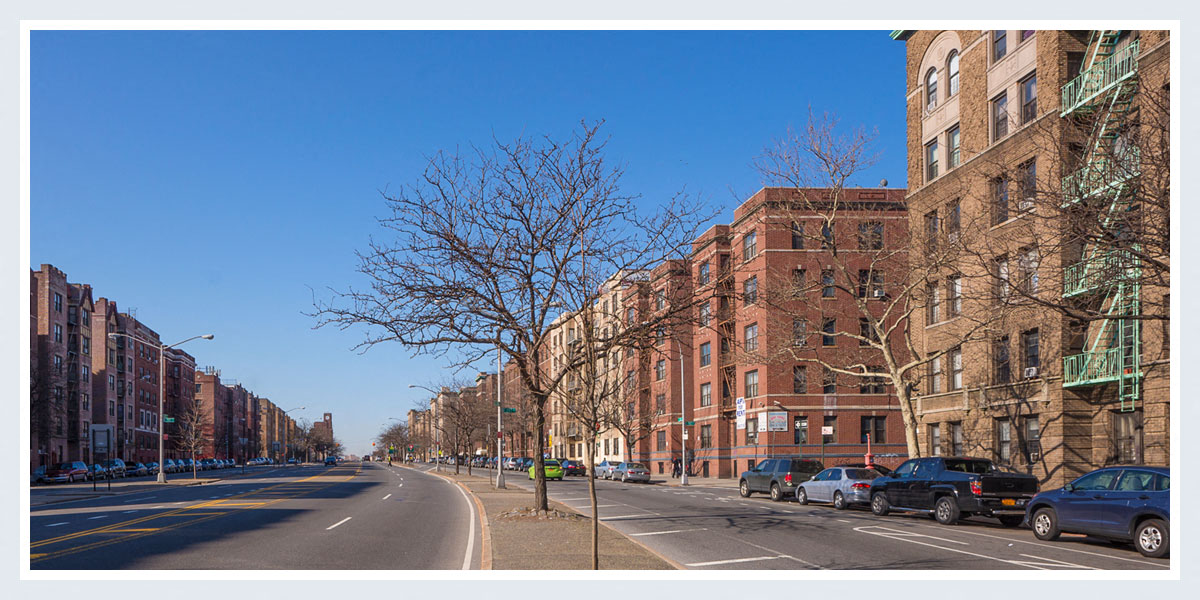 a city street with cars parked in front of tall buildings