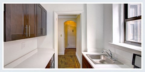 a kitchen with a sink and a window and a hallway