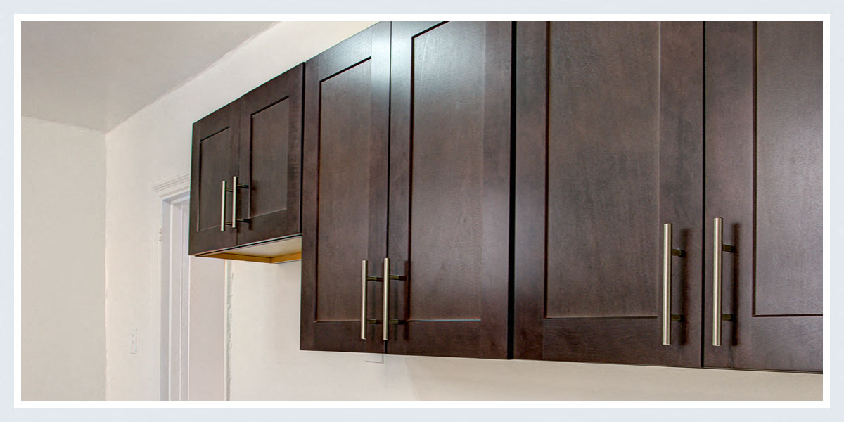a kitchen with wooden cabinets and white walls