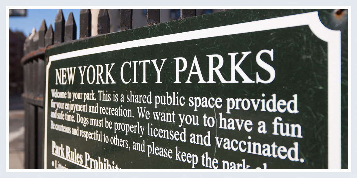 a sign parks in front of a fence