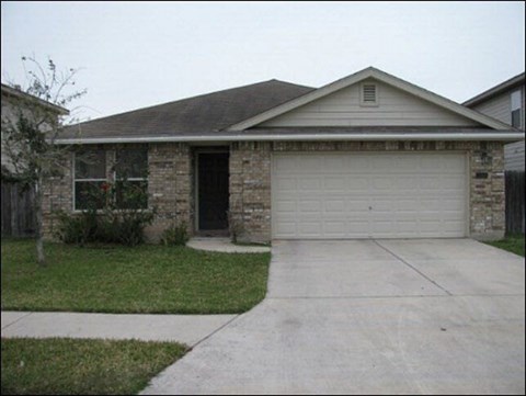 A house with a garage door and a driveway.
