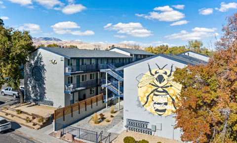 A bee mural is on the side of a building.