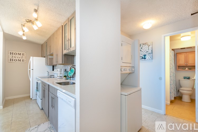 A kitchen with a white fridge and a white toilet in the bathroom.