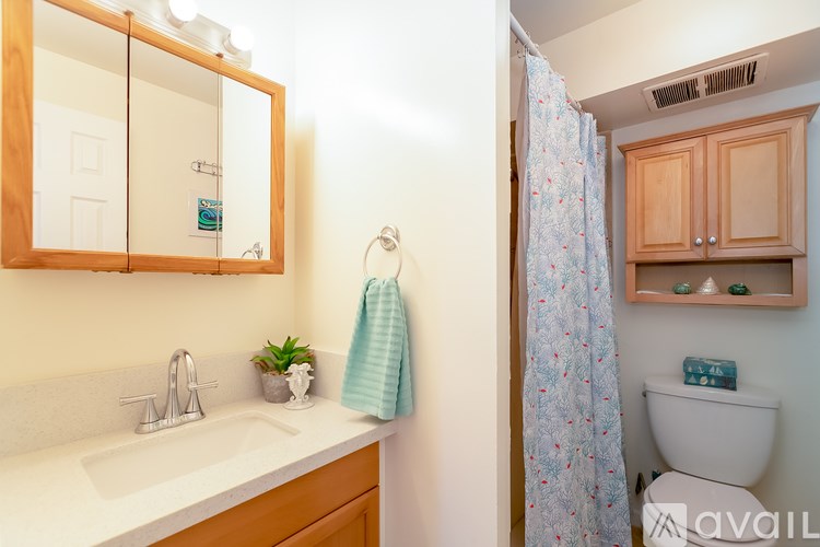 A bathroom with a sink, mirror, toilet, and shower.