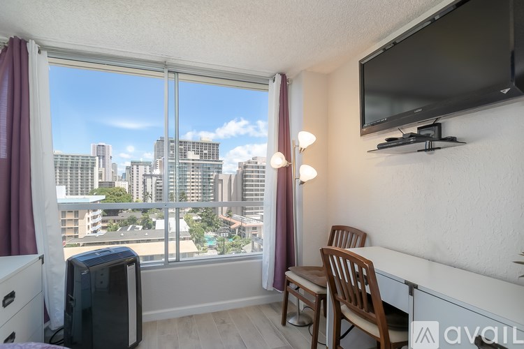 A room with a large window overlooking a cityscape.