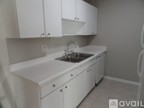 A kitchen with white cabinets and a sink.