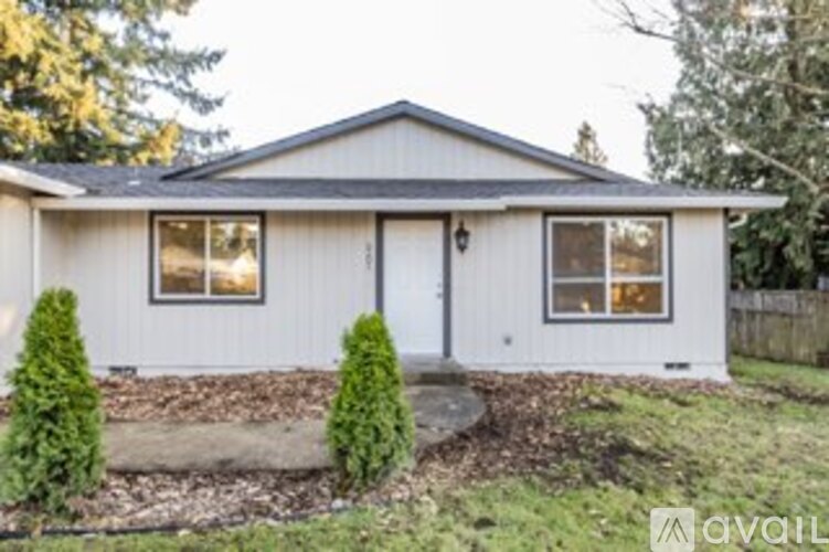 A house with a front yard and a tree.