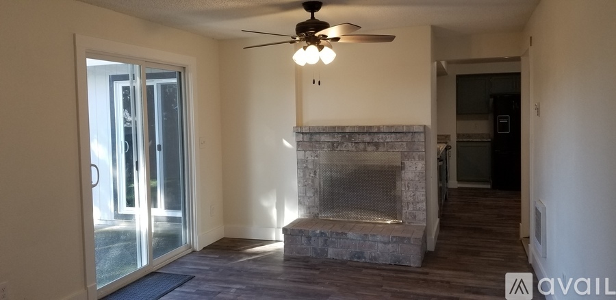 A living room with a fireplace and sliding glass doors.