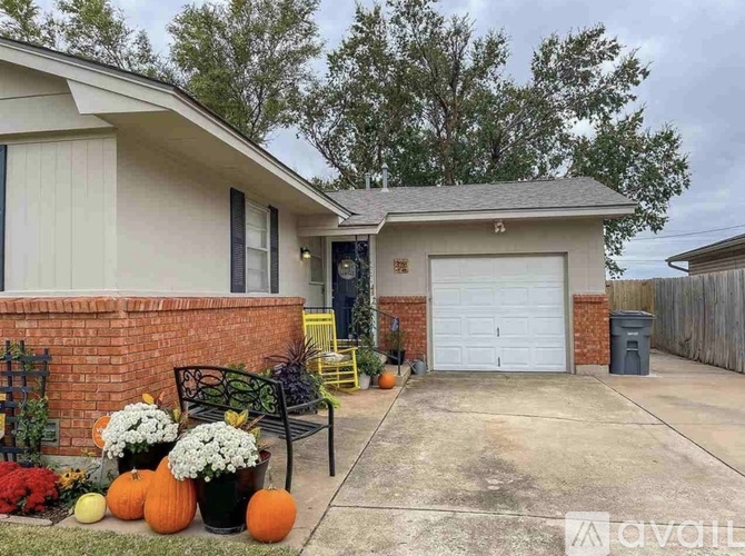A house with a white garage door and a black bench in front of it.