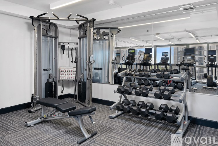 A gym with a variety of equipment including a leg press machine and a bench press.