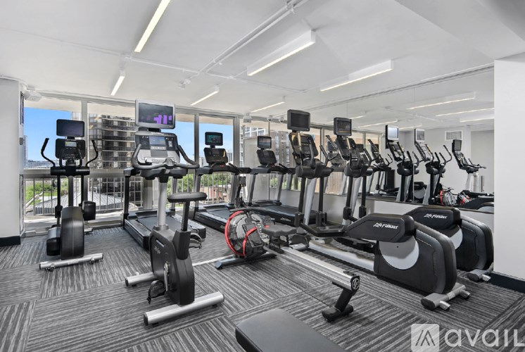A gym with a variety of equipment including treadmills, stationary bikes, and weight machines.
