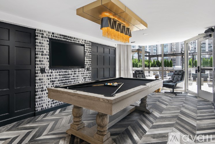 A pool table in a room with a black and white tiled wall.