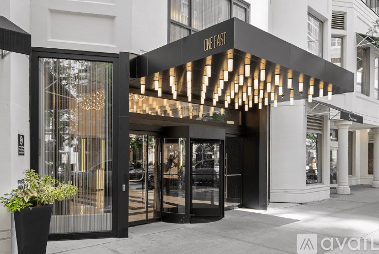 The entrance to a building with a glass door and a sign that reads "One East.".