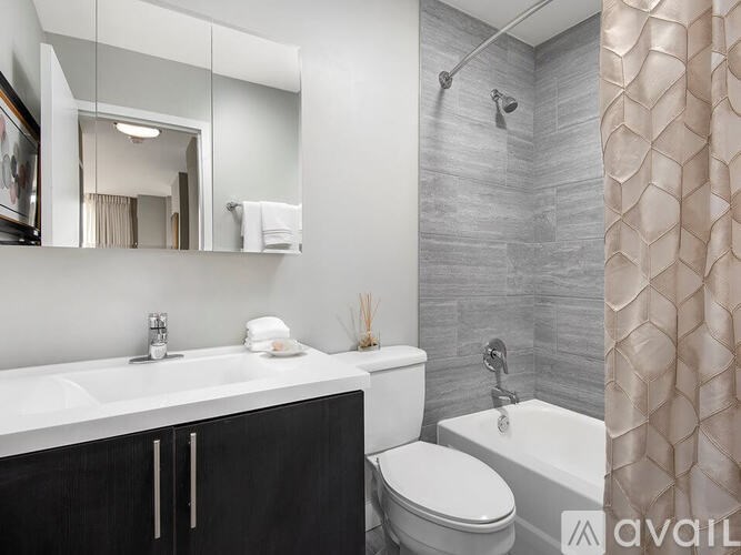A bathroom with a white sink, toilet, and a shower with a curtain.