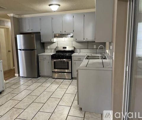 A kitchen with white cabinets and appliances.