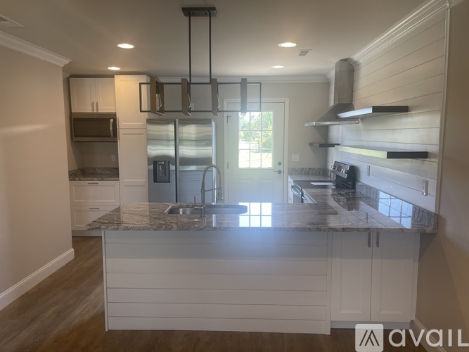 A modern kitchen with a central island and a view of the backyard.