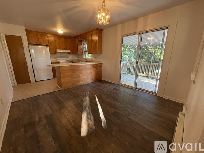 A kitchen with wooden floors and a white refrigerator.