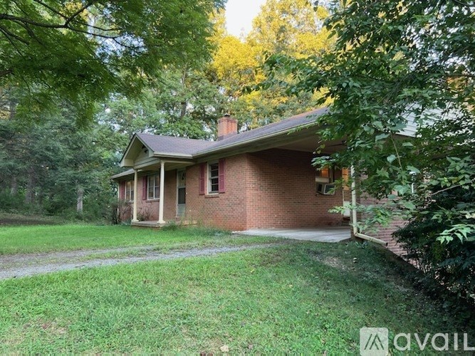 A house with a porch surrounded by trees.