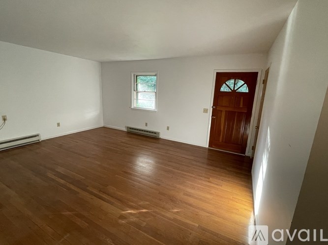 A room with wooden flooring and a window.