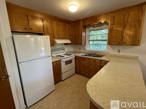 A kitchen with wooden cabinets and a white refrigerator.