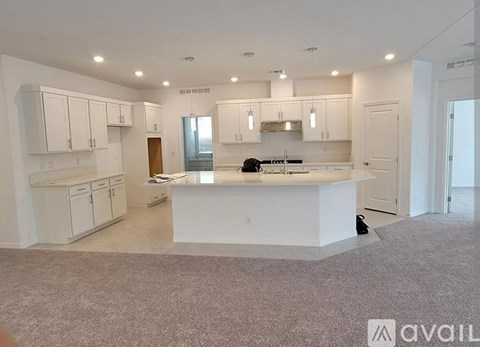 A spacious kitchen with white cabinets and a central island.