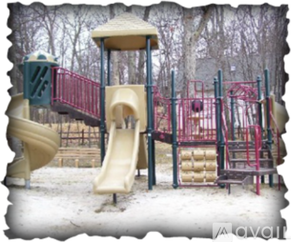 A playground with a yellow slide and red railings.