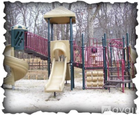 A playground with a yellow slide and red railings.