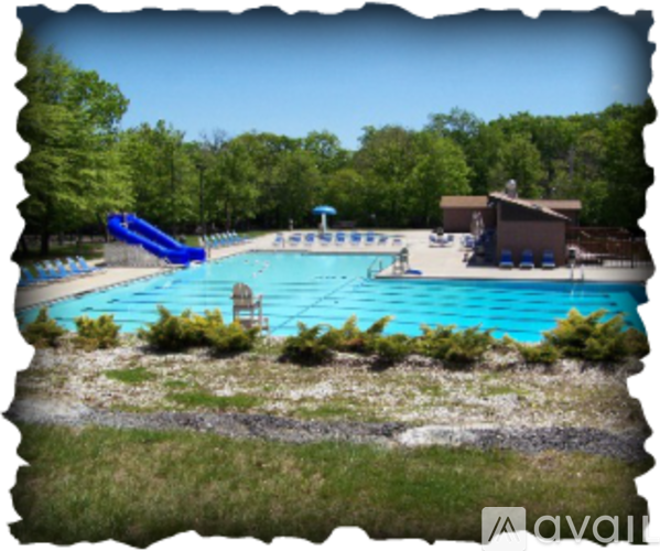 A pool with a slide and a building in the background.