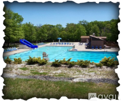 A pool with a slide and a building in the background.