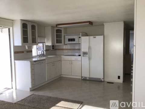 A kitchen with white appliances and cabinets.