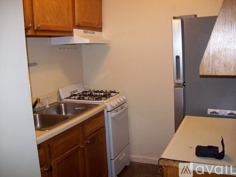 A kitchen with a stove, sink, and refrigerator.