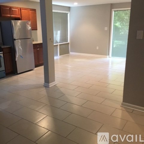A kitchen with a refrigerator and a tiled floor.