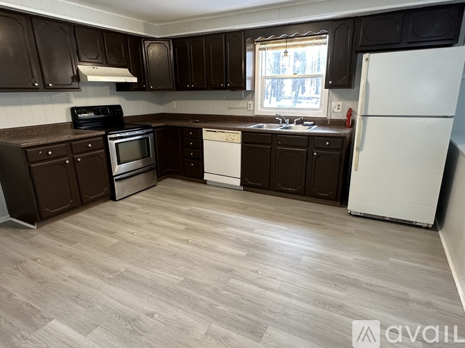 A kitchen with brown cabinets and a white refrigerator.