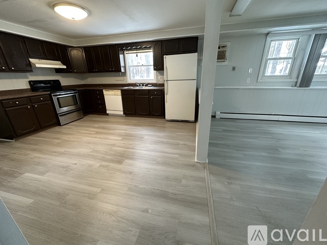 A kitchen with black cabinets and a white refrigerator.