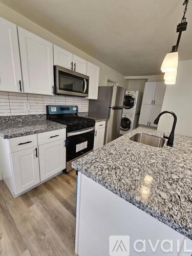 A kitchen with granite countertops and white cabinets.
