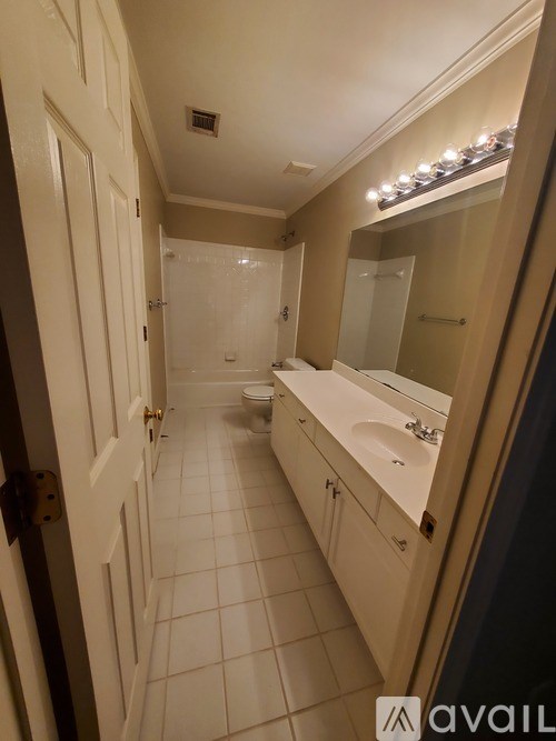 A bathroom with a white tile floor and white walls.