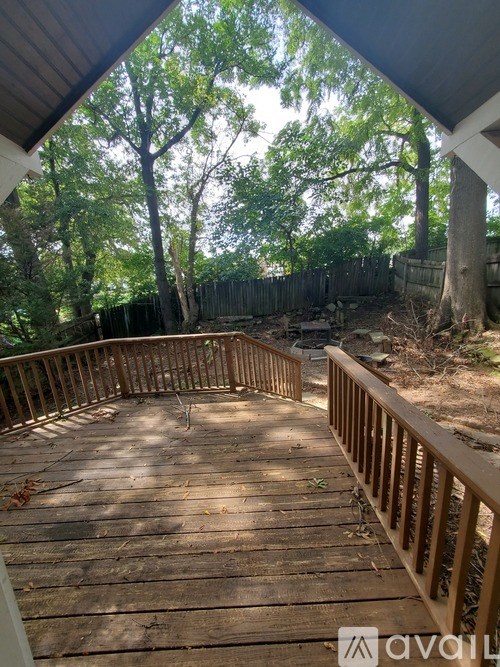 A wooden deck with a railing and trees in the background.
