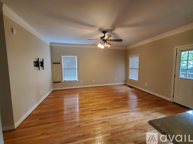 A room with wooden floors and a ceiling fan.