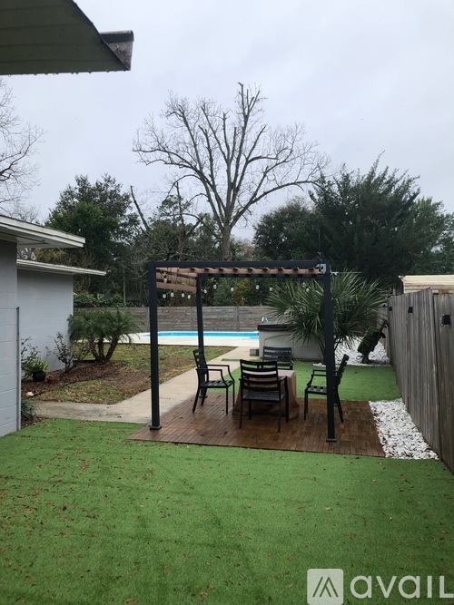 A backyard with a pool and a pergola.