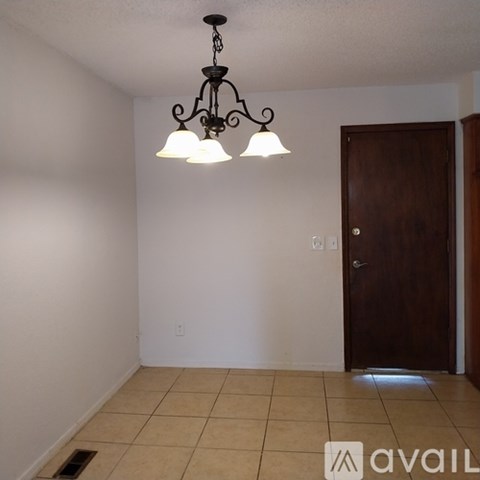 A room with a chandelier and a door.
