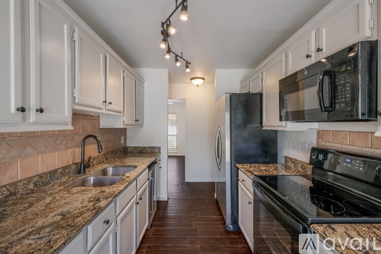 A kitchen with granite countertops and white cabinets.