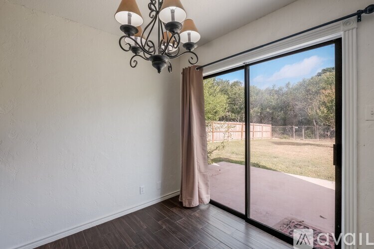 A room with a chandelier and sliding glass doors.